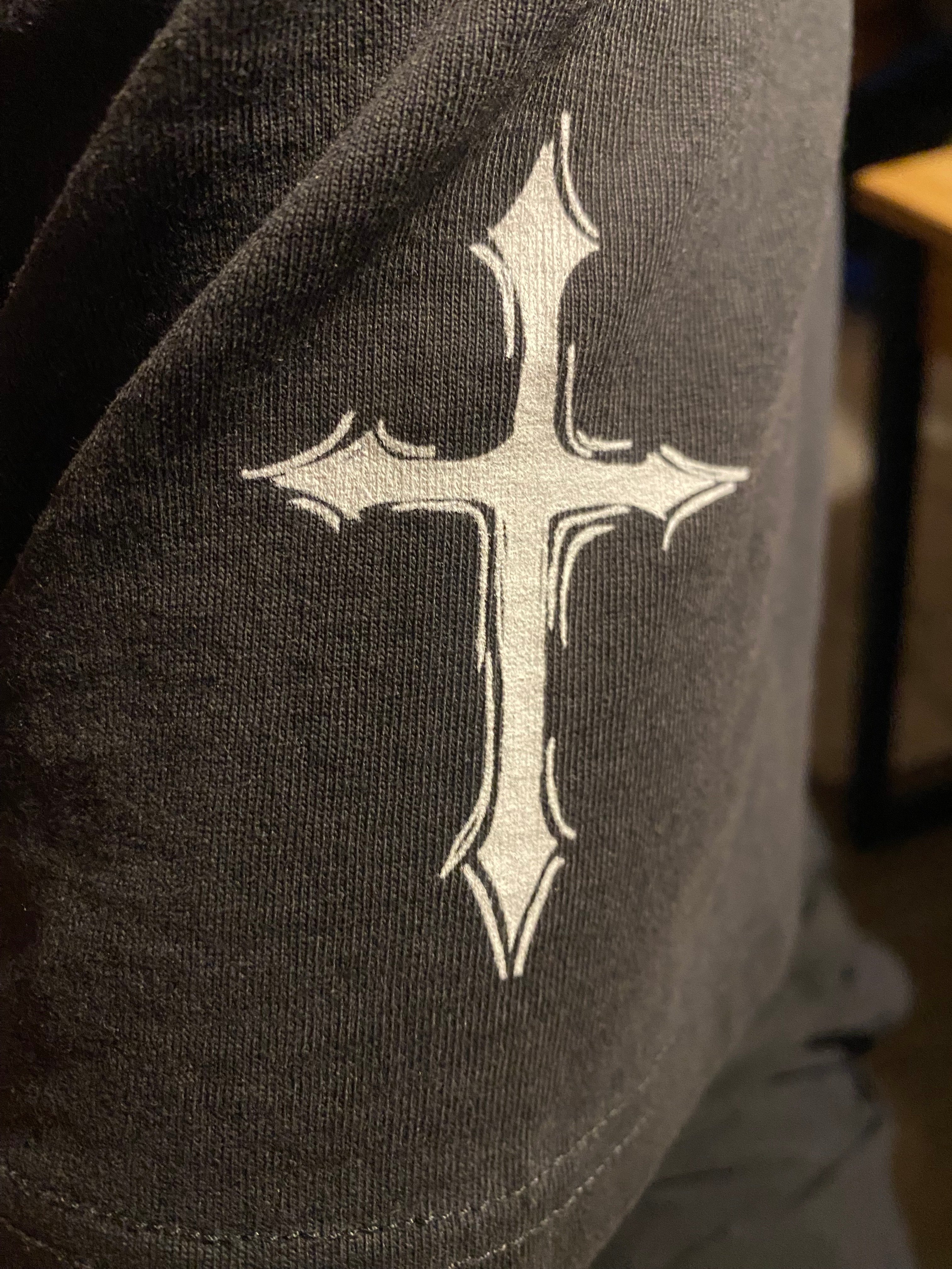 Black fabric with a white printed cross design on a blurred background